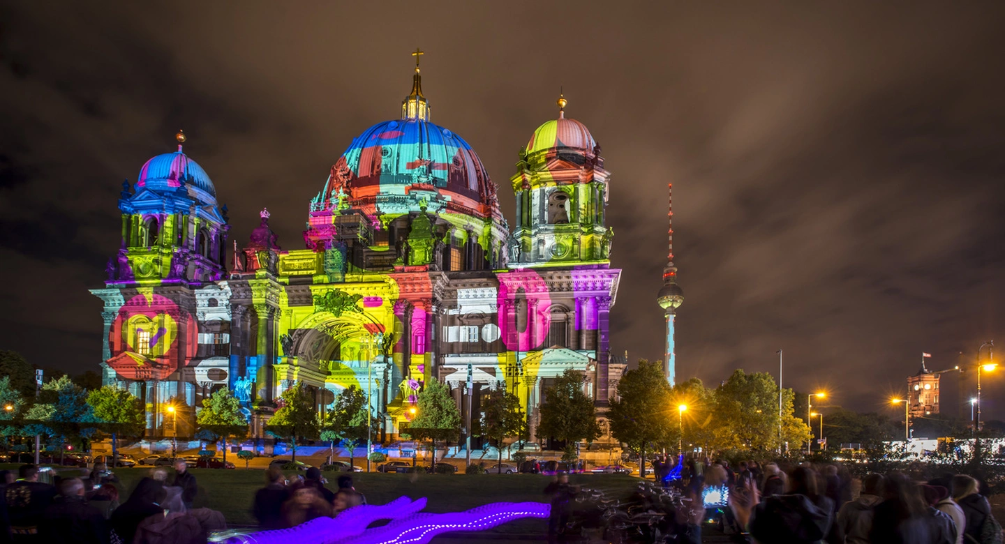 Berlin Cathedral and TV Tower illuminated with vibrant light projections during the Festival of Lights 2024 in Berlin.
