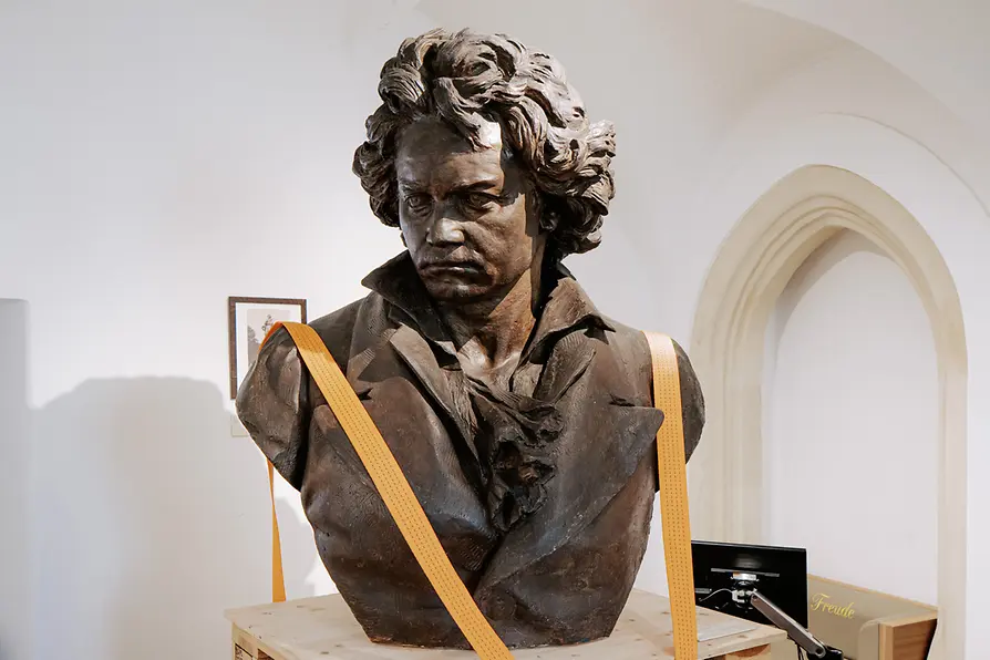 Stern bronze bust of Ludwig van Beethoven, secured with orange straps, featured on the Ivie's Beethoven audio walk.