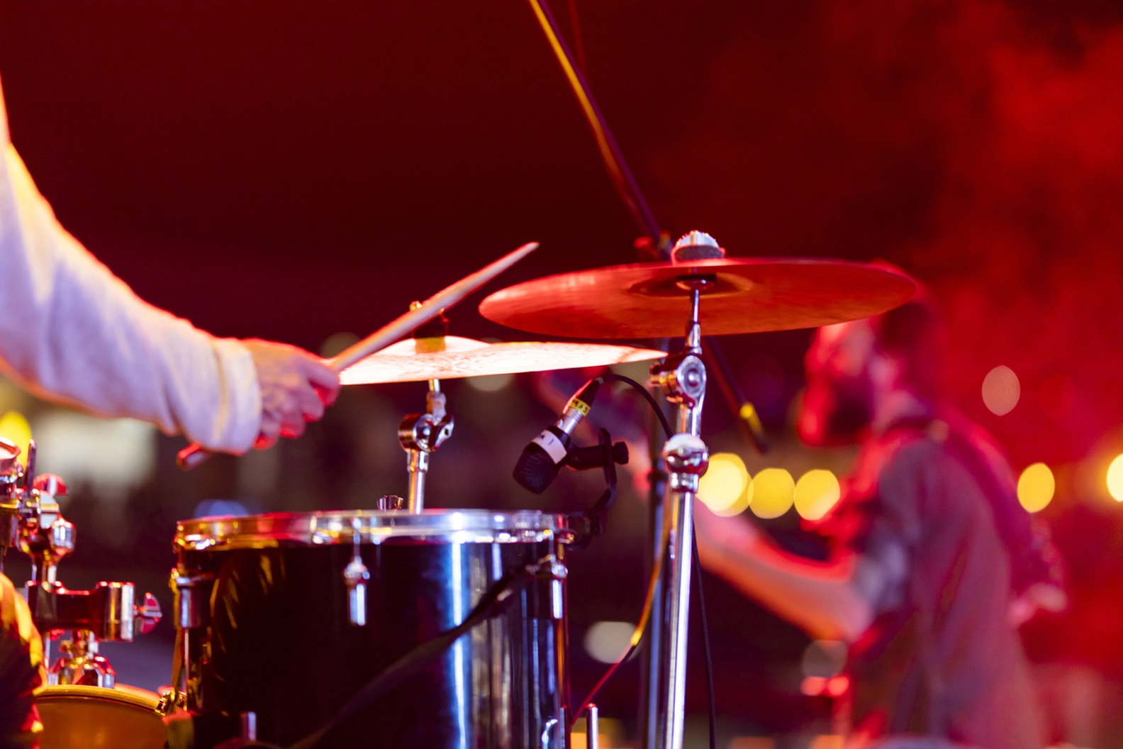 Drummer performing live on stage with red lights, capturing the international sounds experience at Berlin's Humboldt Forum.
