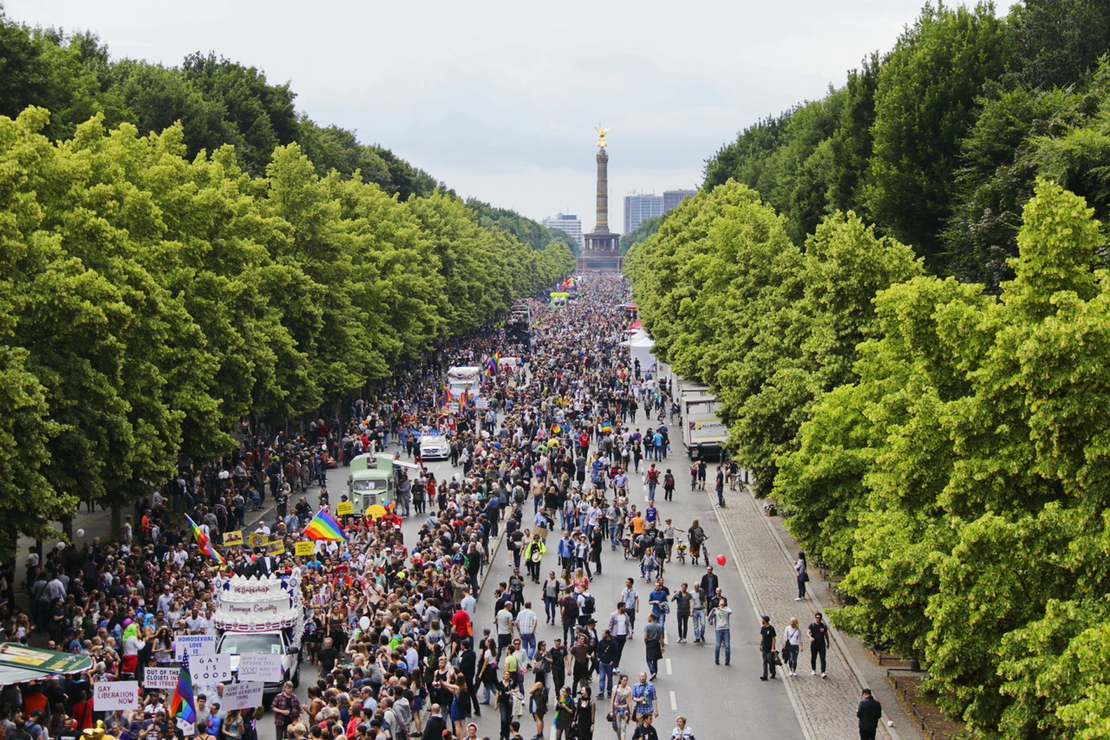 Summer Berlin Pride (CSD) parade with thousands celebrating on a tree-lined avenue leading to the iconic Victory Column (Siegessäule).