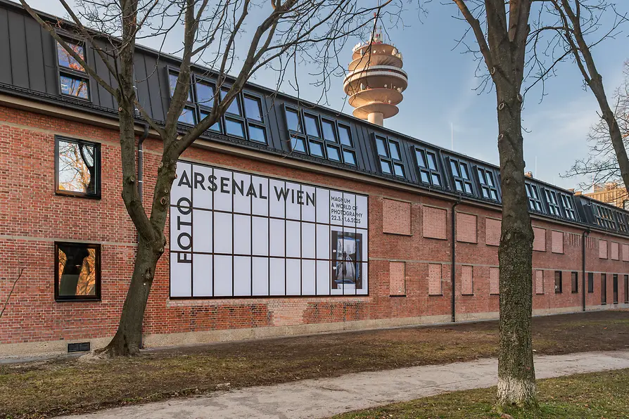 Foto Arsenal Wien museum facade in autumn, featuring the 'Magnum: A World of Photography' exhibition banner, highlighting Vienna's dedication to art.